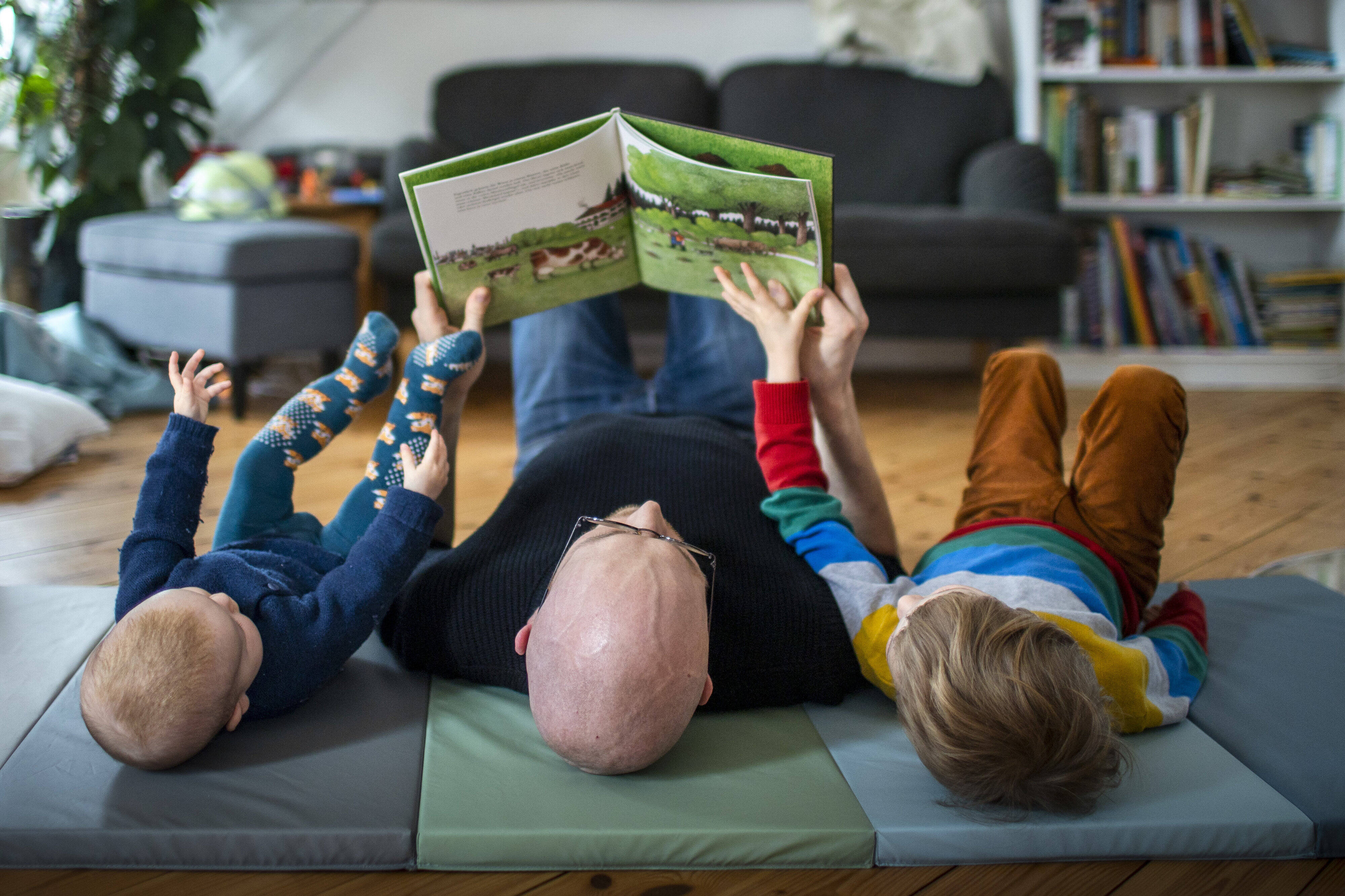 Ein Vater liest seinen Kindern vor, was deren Empathievermögen und Gerechtigkeitsempfinden steigert Ein Vater liest seinen Kindern vor, was deren Empathievermögen und Gerechtigkeitsempfinden steigert