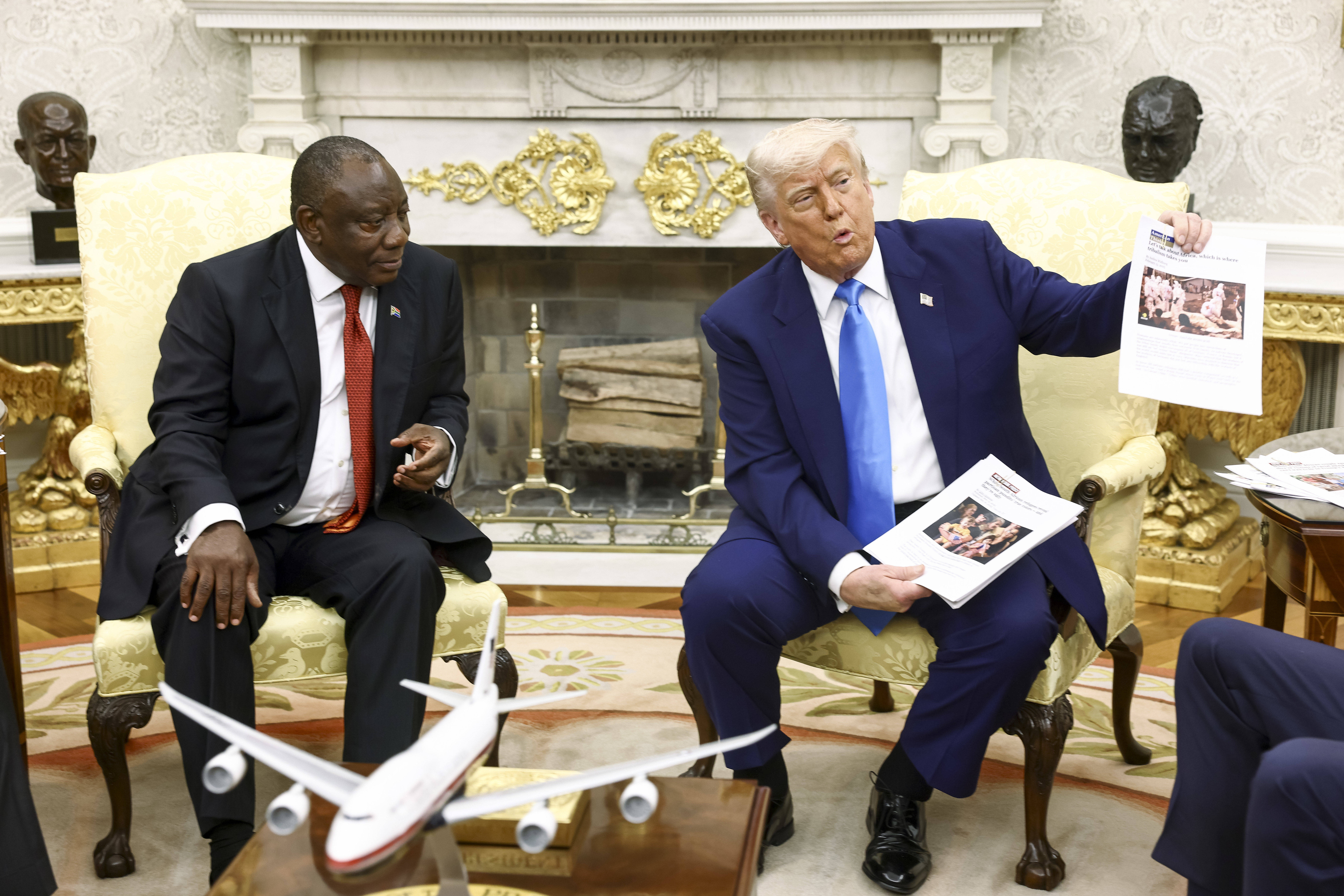 Donald J. Trump, rechts, hält während eines Treffens mit Präsident Cyril Ramaphosa von Südafrika im Oval Office Zeitungsartikel hoch, die sich auf Gewalt in Südafrika beziehen.