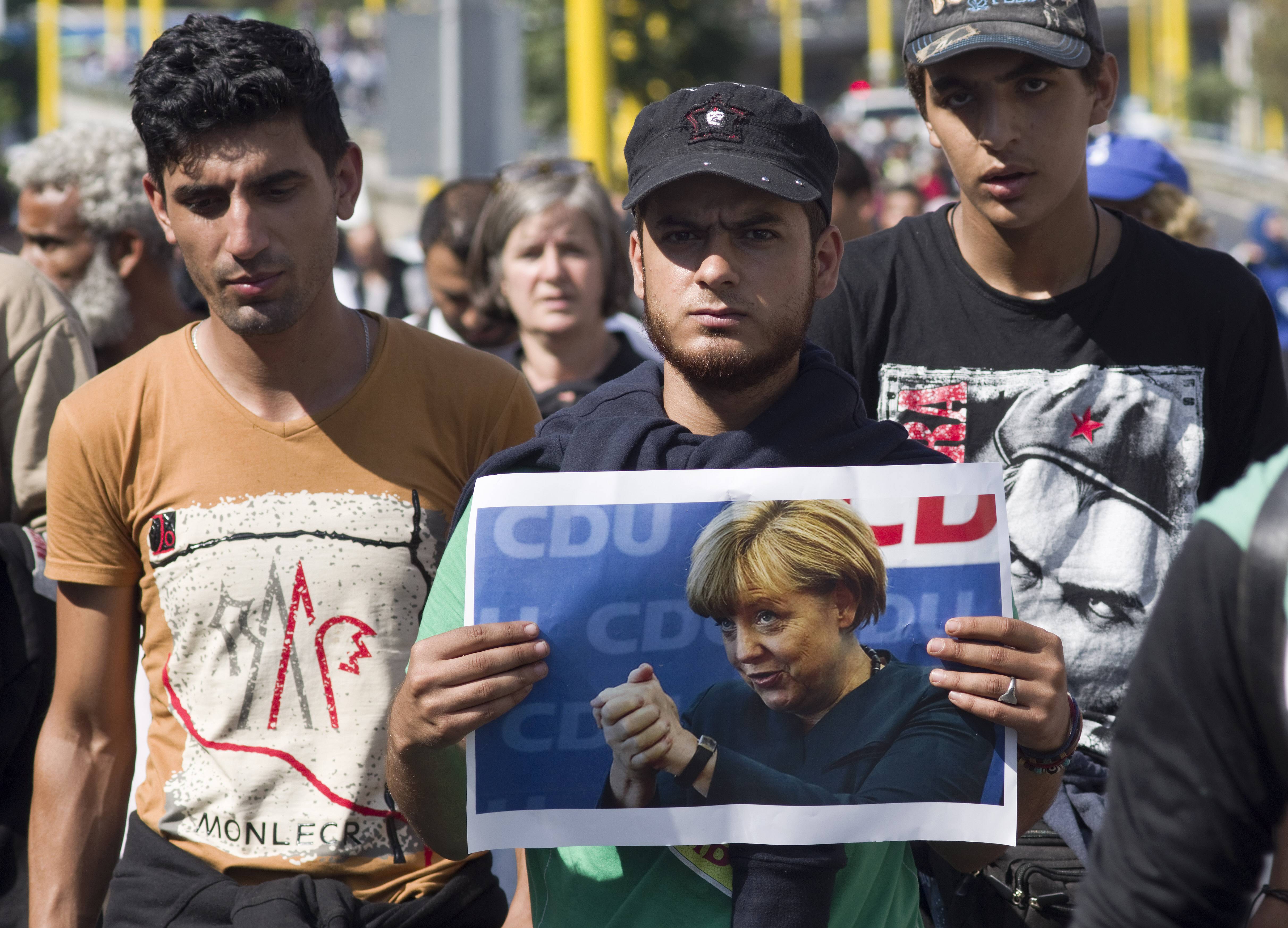 Migranten aus Nahost in Budapest mit Plakat der damaligen CDU-Bundeskanzlerin Angela Merkel, 4. September 2015