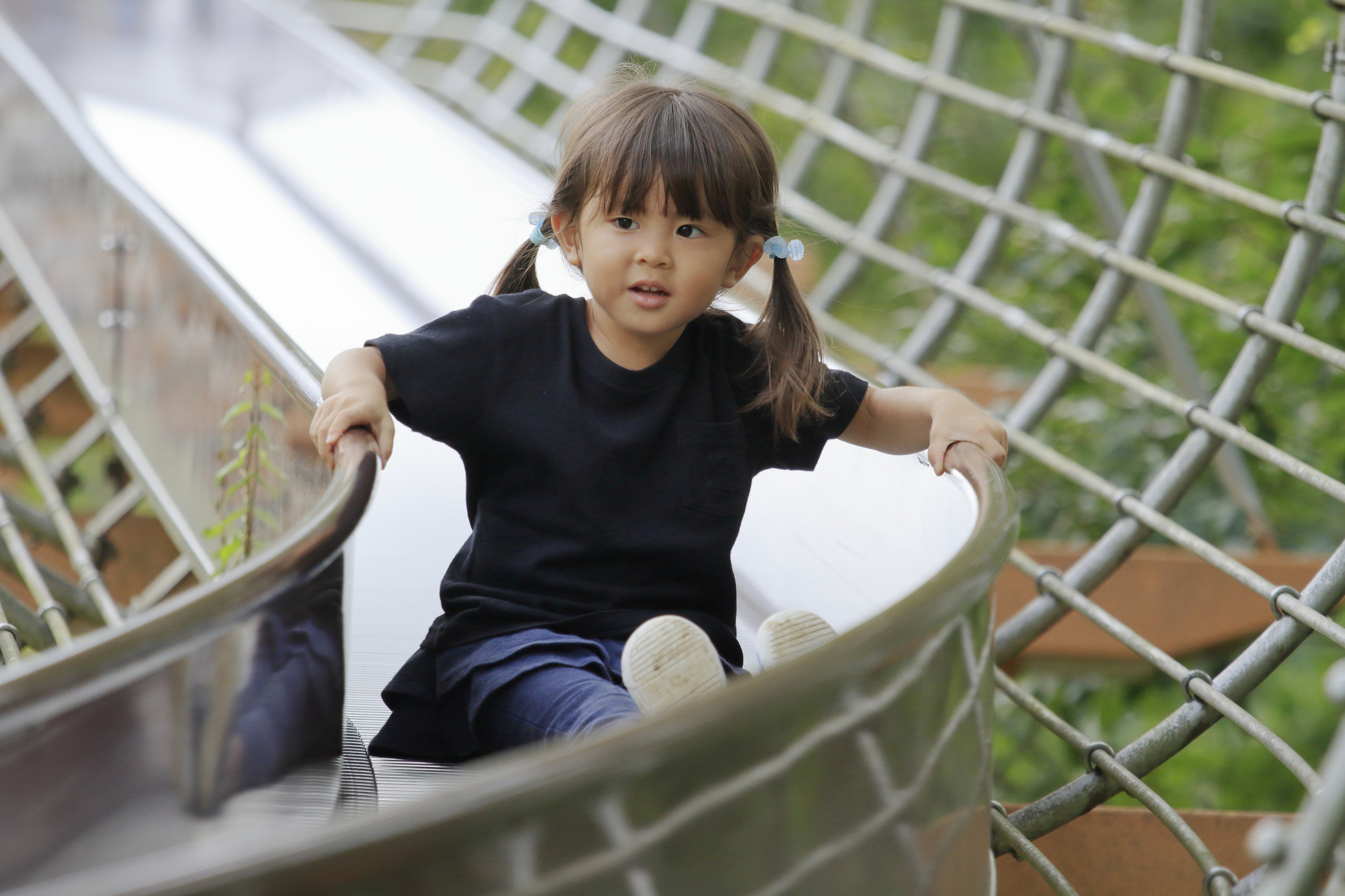 Dreijähriges japanisches Mädchen auf einer Rutsche