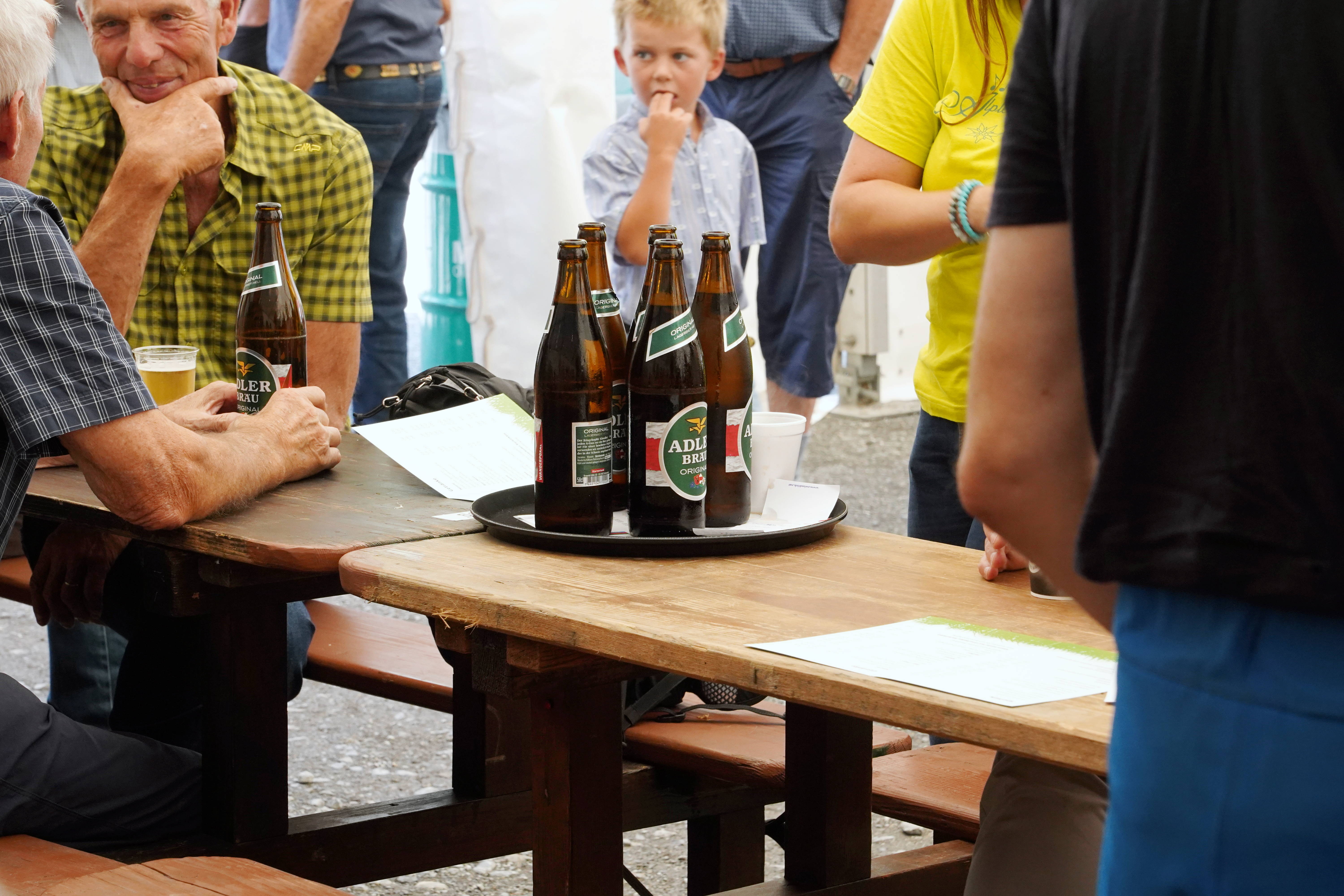 Schweizer Adler-Bräu-Bierflaschen auf Festtisch im Freien
