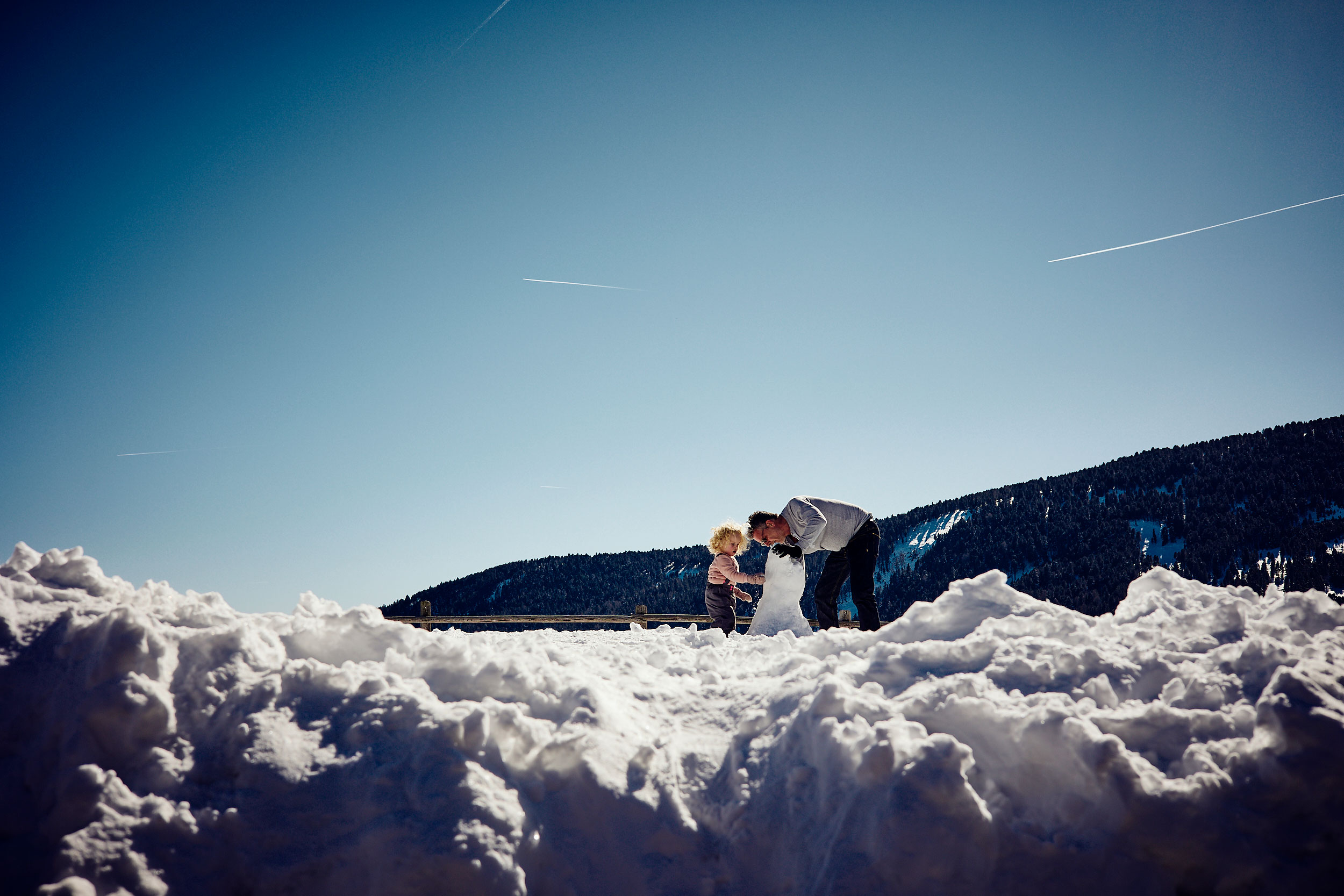 Vater mit Tochter spielen im Schnee und Eis