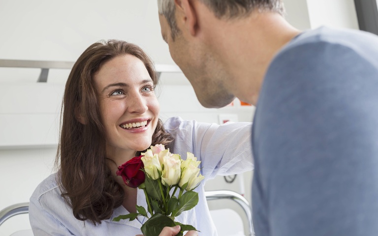 Besuch mit Blumen am Krankenbett