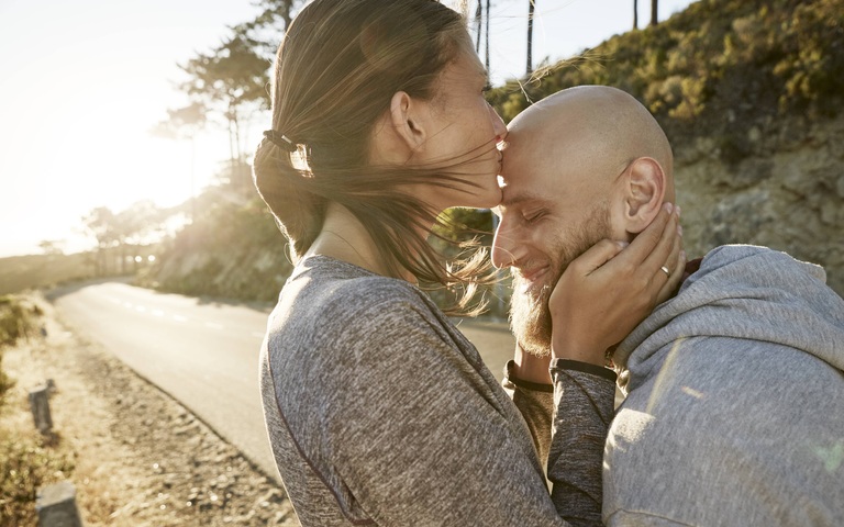 Young woman kissing husband on his forehead, model released, Symbolfoto