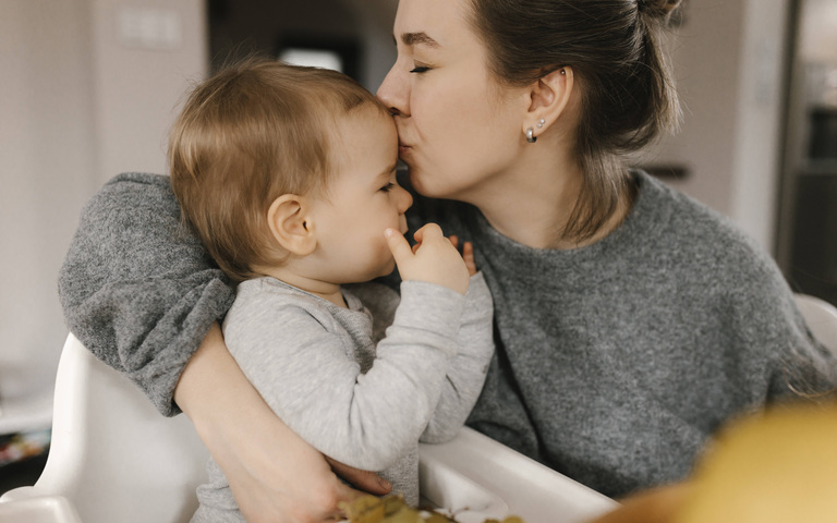Mother kissing son on forehead at home model released, Symbolfoto property released