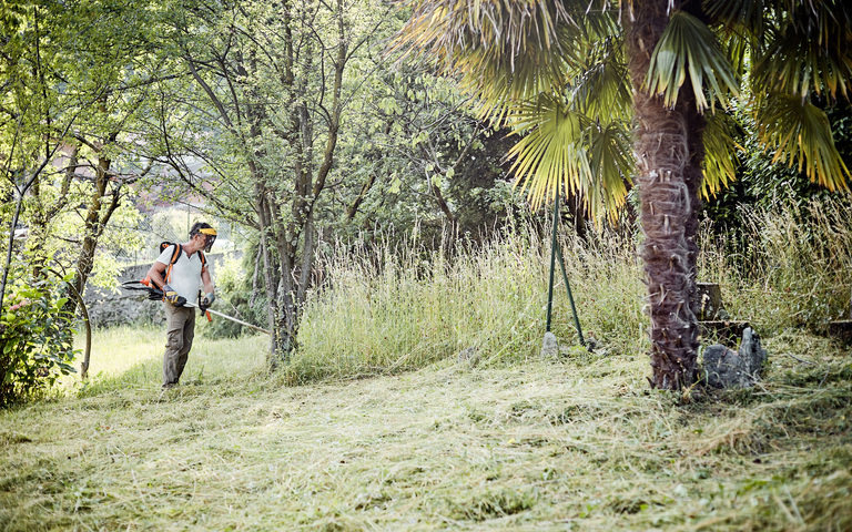 Oliver Stock beim Rasenmähen