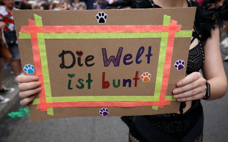 Pappschild „Die Welt ist bunt“ auf dem 31. Christopher Street Day (CSD) in Frankfurt/Main, Deutschland, 15.07.2023