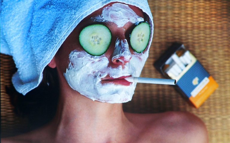 Junge Frau mit Gesichtsmaske, rauchend