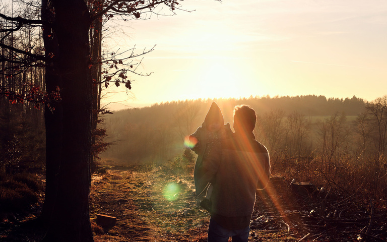 Oliver Stock bei Waldwanderung mit Töchterchen auf dem Arm im Abendlicht