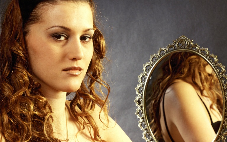 Porträt einer jungen Frau neben einem Spiegel