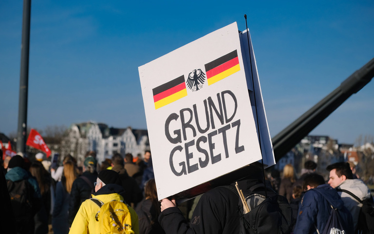 Demonstranten halten ein Grundgesetz aus Pappe auf einem Protestzug gegen AfD und „gegen rechts“ in die Höhe, Düsseldorf, 27.01.2024