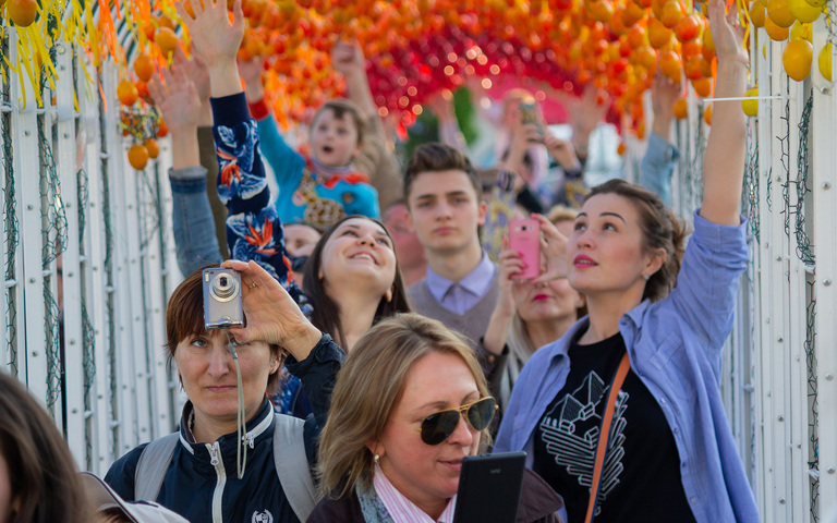 Fröhliche Menschen in Kiew gehen unter einem Tunnel aus Ostereiern hindurch