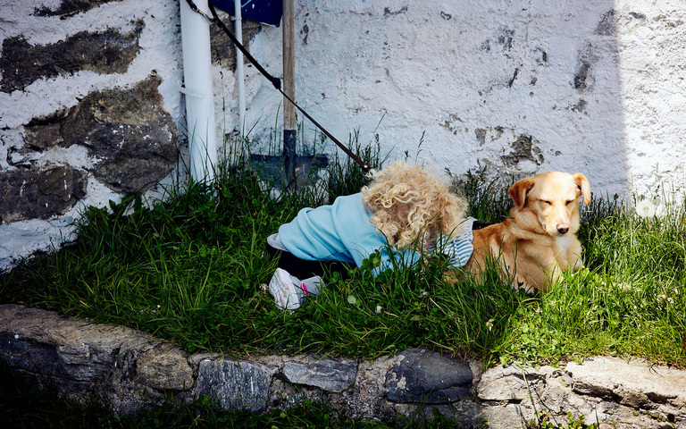 Das Töchterchen macht zusammen mit der Hündin ein Nickerchen