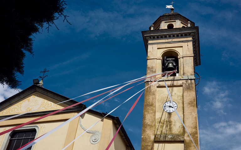 Turm einer italienischen Dorfkirche im Festschmuck zu Pfingsten