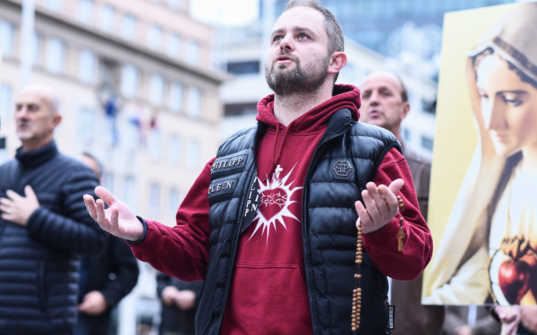 Mann betet öffentlich Rosenkranz