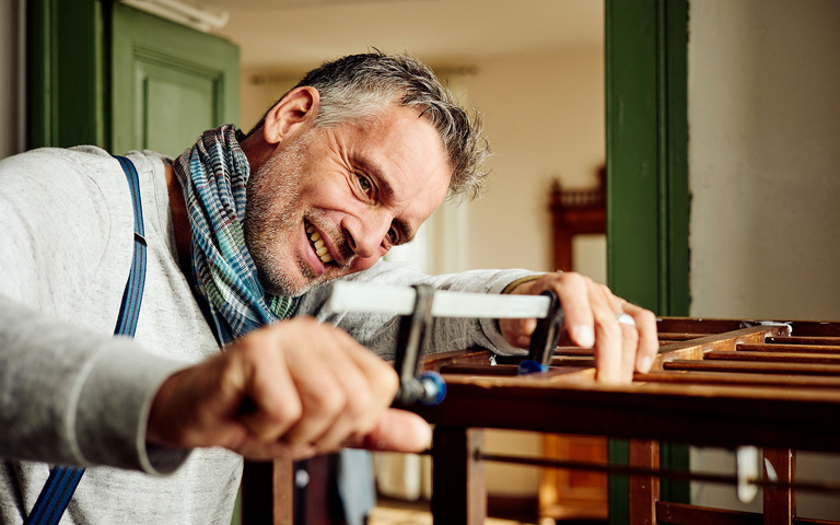 Oliver Stock beim Reparieren eines Kinderbettchens
