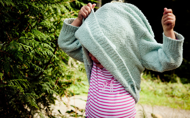 Töchterchen beim Anziehen eines Pullovers