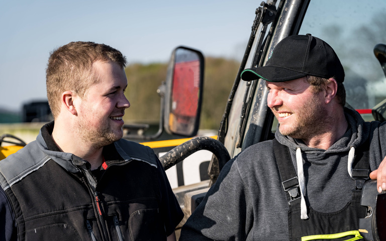Vertrauensvolles Arbeitsverhältnis zwischen Landwirt und seinem Sohn (landwirtschaftliches Symbolfoto)