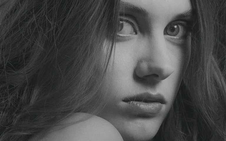 Porträtaufnahme einer jungen Frau mit nackter Schulter