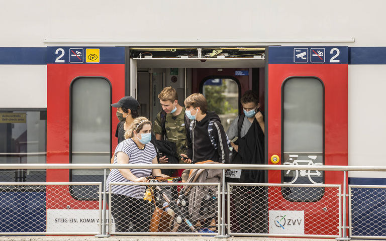 Aussteigende Fahrgäste mit Masken an einer Schweizer Bahnstation während der Coronamaßnahmenzeit, August 2020
