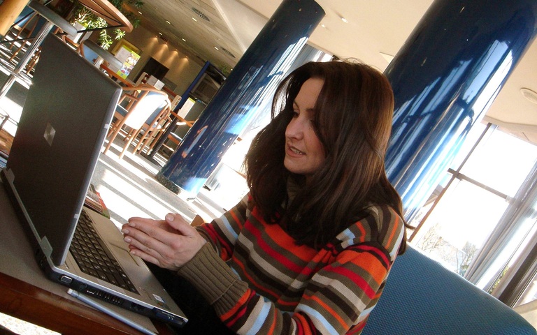 Junge Frau betet vor dem Laptop