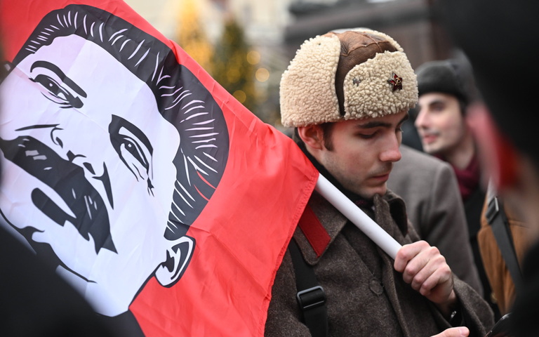Ein Anhänger der KP Russlands nimmt mit einer Stalin-Fahne an einer Blumenniederlegung am Grab Josef Stalins an der Kremlmauer anlässlich des 145. Geburtstages des sowjetischen Führers in Moskau teil, 21.12.2024