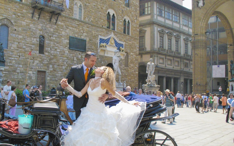 Frisch verheiratetes Paar mit Hochzeitskutsche in Florenz, Italien