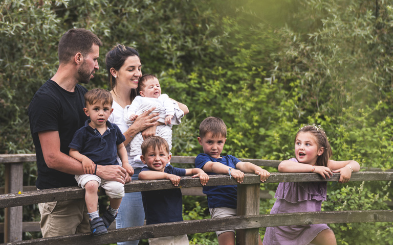 Ehepaar mit fünf kleinen Kindern in einem Park
