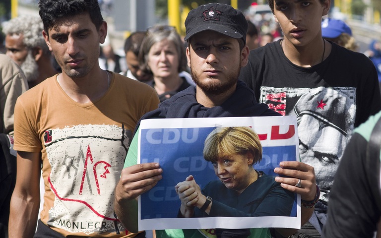 Migranten aus Nahost in Budapest mit Plakat der damaligen CDU-Bundeskanzlerin Angela Merkel, 4. September 2015