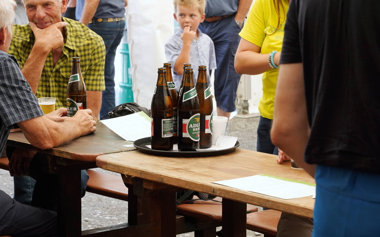 Schweizer Adler-Bräu-Bierflaschen auf Festtisch im Freien