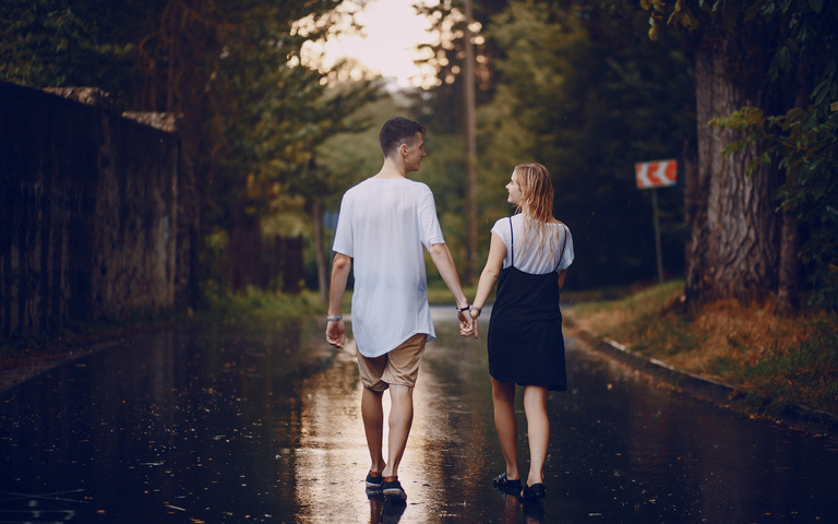 Ein junges Liebespaar auf regennasser Straße