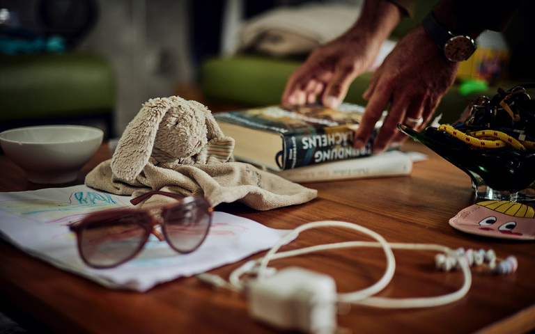 Eine Brille, ein Stofftier-Hase und ein Buch auf einem Tisch